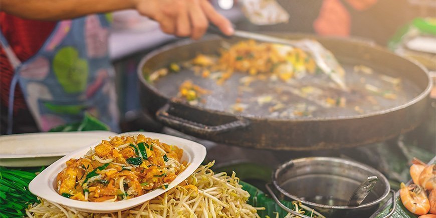 Woman making Pad Thai at a market in Bangkok