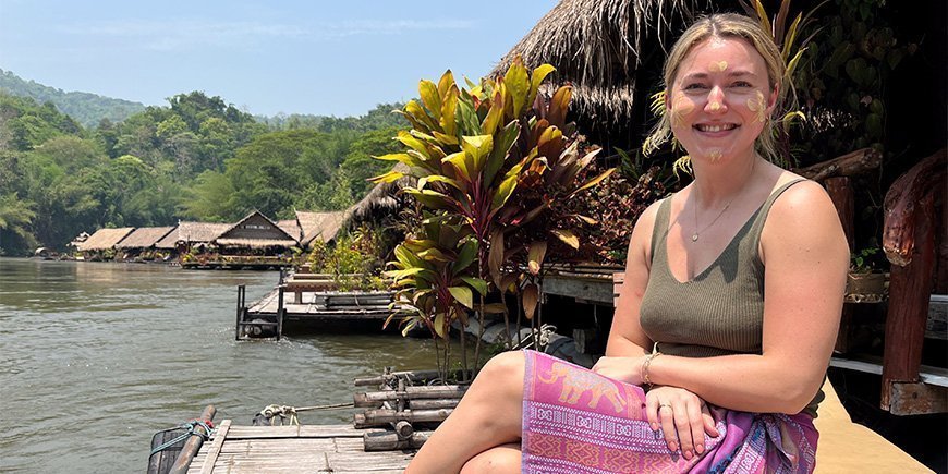 Cecilie from TourCompass on a bench by River Kwai