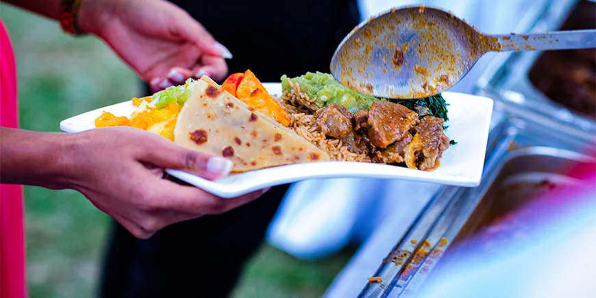 Woman holding a plate of food in Kenya
