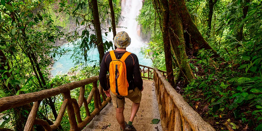 Man walking down stairs towards La Fortuna waterfall