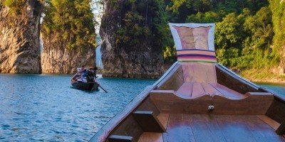 Longtail boat sailing on Cheow Lan Lake in Khao Sok